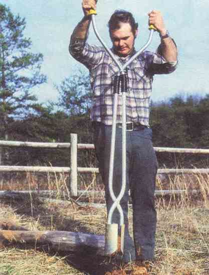A homesteader takes his first bite of dirt with the posthole digger.